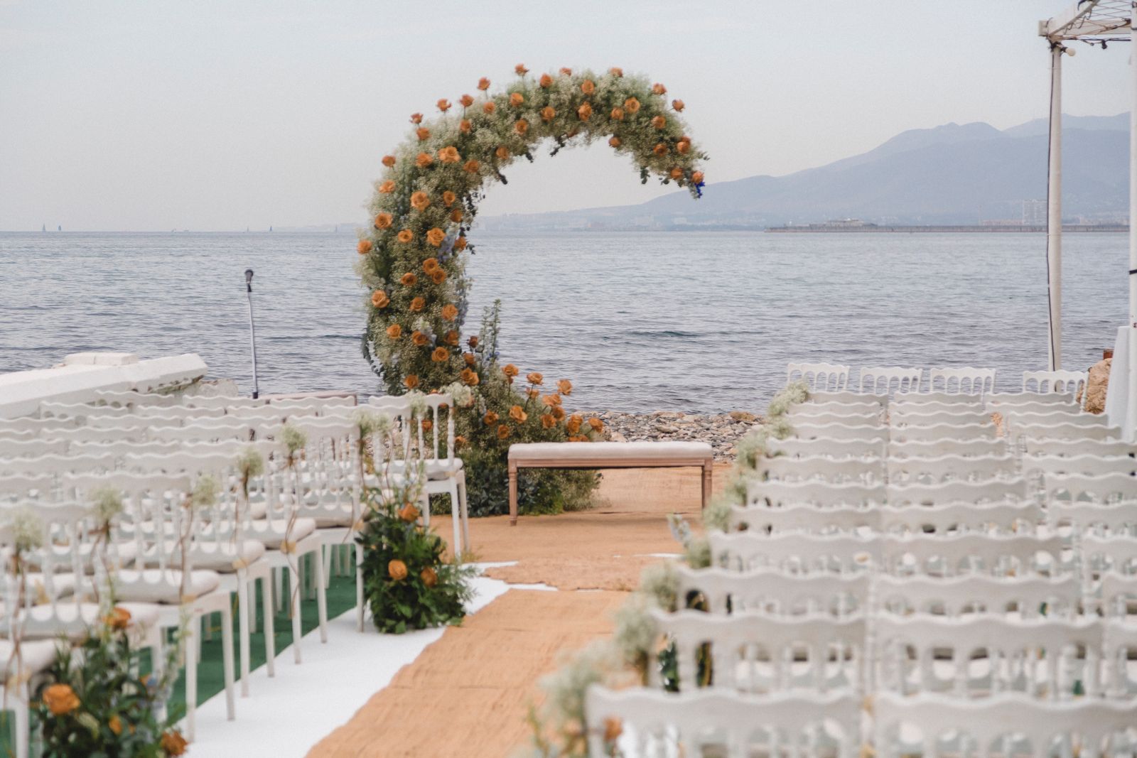 Arco floral y sillas de ceremonia frente al Mediterráneo