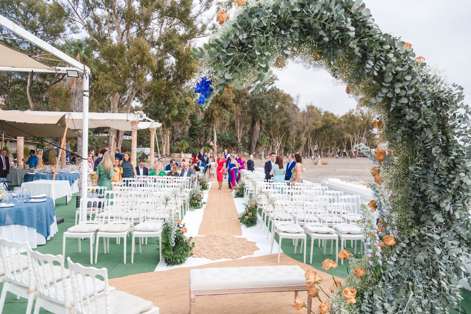 Ceremonia con invitados y arco floral frente al mar