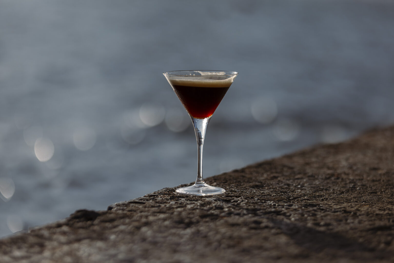 Espresso martini sobre el muro, junto al agua