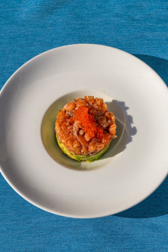 Tartar de salmón marinado con huevas, sobre mantel azul